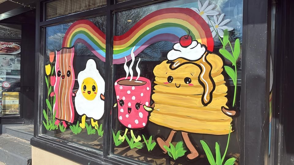 Hand-painted right front window — bacon, egg, coffee, and a stack of pancakes under a rainbow